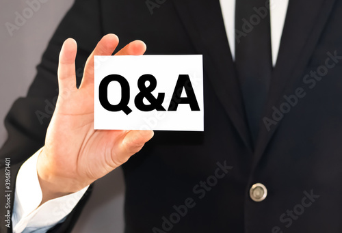 Q and A Questions and Answers sign on business card shown by a man