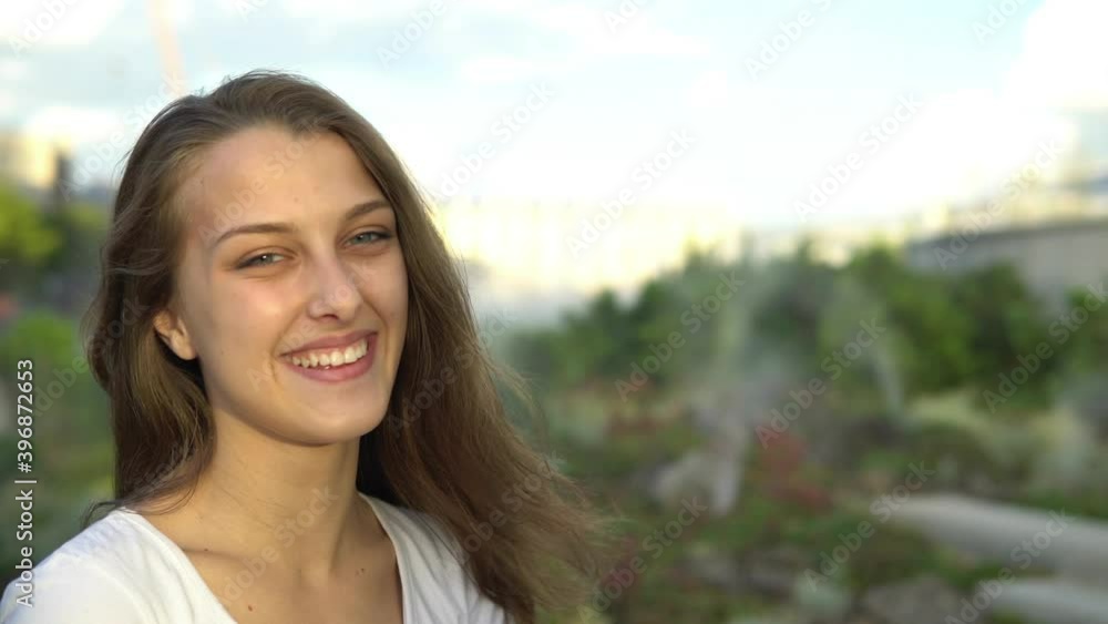 Beautiful girl with a smile on the background of the city park Beautiful girl with a smile on the background of the city park
