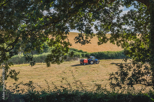 Tractor working on the farm in the Restormel castle surrounding landscape., Uk. photo