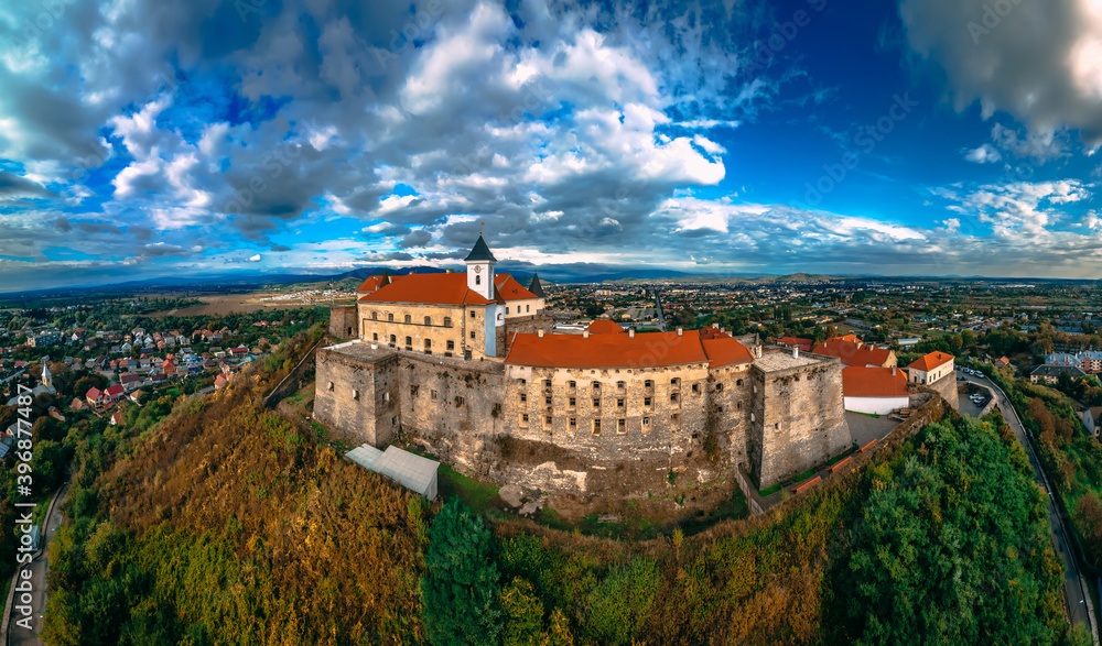 Aerial view of medieval castle on mountain in small european city in autumn season