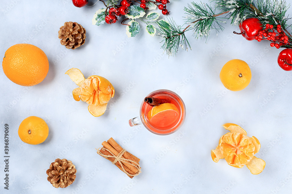 Winter composition, Alcoholic or non-alcoholic cocktail of tangerines, oranges and cinnamon with spices, warming winter drink in the cold season, Christmas festive grog, flat lay