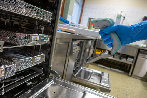 a hospital employee scans instrument trays with a barcode scanner