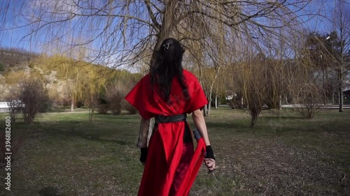 Asian man wear red kimono and playing with katana sword. Cosplay actor