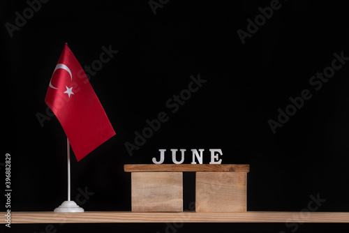 Wooden calendar of June with Turkish flag on black background. Holidays of Turkey in June.