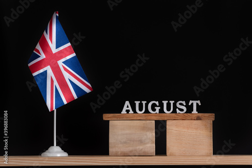 Wooden calendar of August with Great Britain flag on black background. Holidays of UK in August .