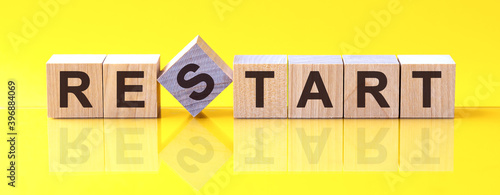 restart word is made of wooden building blocks lying on the yellow table, concept