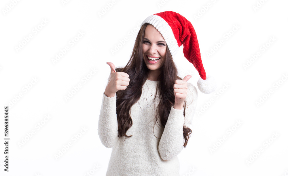 Smiling happy woman in santa claus hat standing isolated over white Smiling happy woman in santa claus hat standing isolated over white