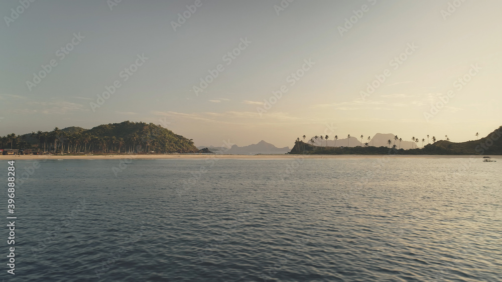 Nobody seascape of mountains with green tropic forest at sand beach aerial. Ocean bay with sandy coast and palm trees on hills. Philippines paradise islands of El Nido. Cinematic drone shot Nobody seascape of mountains with green tropic forest at sand beach aerial. Ocean bay with sandy coast and palm trees on hills. Philippines paradise islands of El Nido. Cinematic drone shot