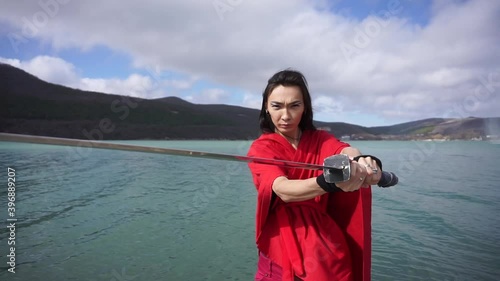 Asian man wear red kimono and playing with katana sword. Cosplay actor