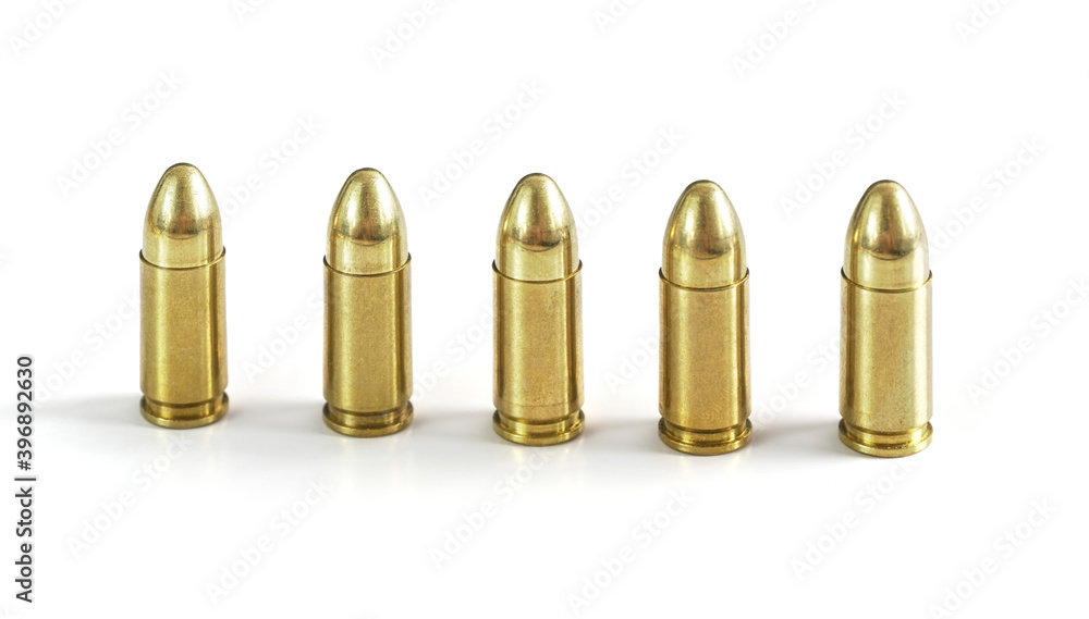 Five yellow brass ammo bullets isolated on white background, arranged standing next to each other Five yellow brass ammo bullets isolated on white background, arranged standing next to each other