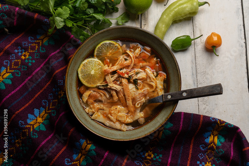 Mexican lime soup with chicken on white background photo