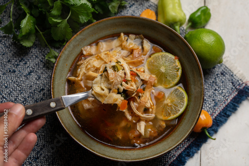 Mexican lime soup with chicken on white background photo