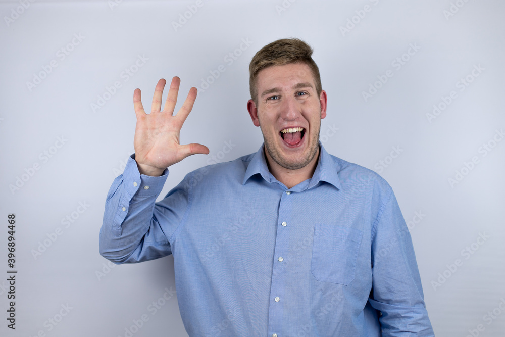 Business young man wearing a casual shirt over white background smiling confident and happy showing number five with fingers Business young man wearing a casual shirt over white background smiling confident and happy showing number five with fingers