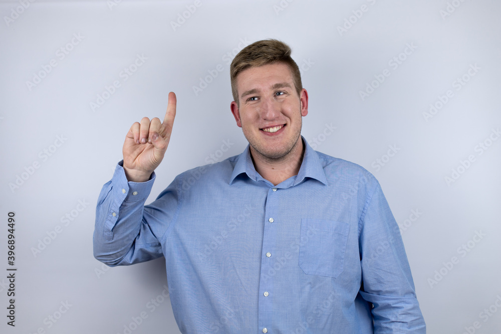 Business young man wearing a casual shirt over white background smiling confident and happy showing number one with fingers Business young man wearing a casual shirt over white background smiling confident and happy showing number one with fingers