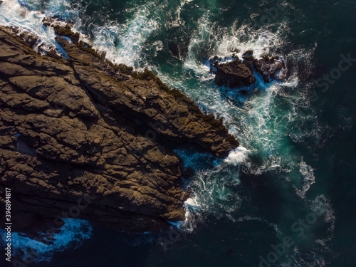Aerial top view of ocean waves and fantastic rocky coast. Wallpaper design. Amazing landscape. Amazing view from above. Concept of wild nature.