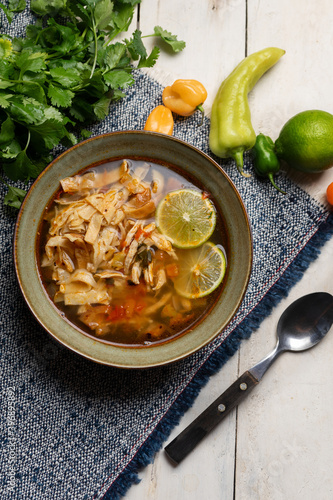 Mexican lime soup with chicken on white background photo