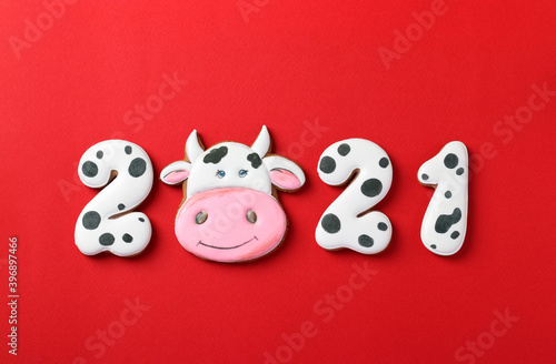 Gingerbread cookies in the form of numbers 2021and bull  gifts on christmas or Noel holiday  Happy New Year  red background. Top view