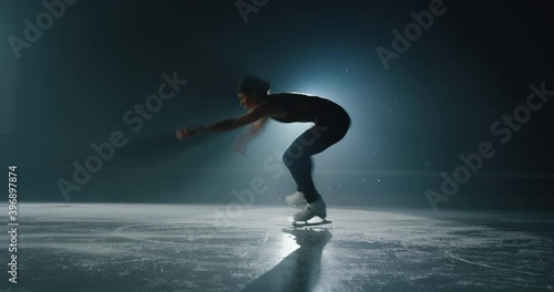 Cinematic shot of young female artistic figure skater is performing a woman's single skating choreography on ice rink before start of a competition. Concept of perfection, precision, freedom, passion.
