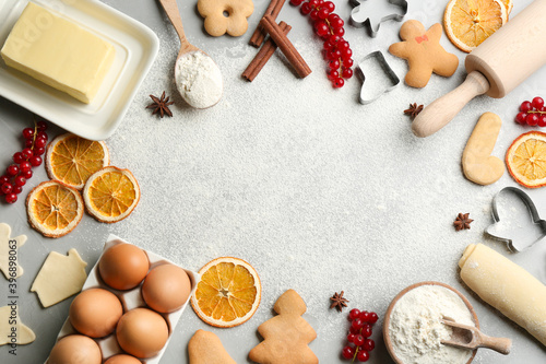 Flat lay composition with homemade Christmas cookies and ingredients on grey table, space for text