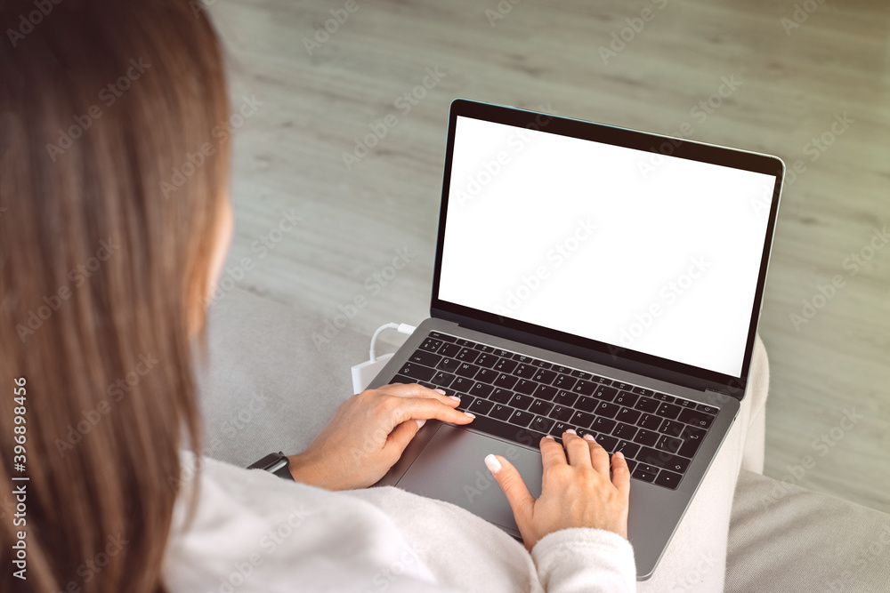 Close up of woman working at home on a laptop with blank white screen. Online education. Laptop screen with copy space, mockup. Female hands typing on a laptop keyboard Close up of woman working at home on a laptop with blank white screen. Online education. Laptop screen with copy space, mockup. Female hands typing on a laptop keyboard