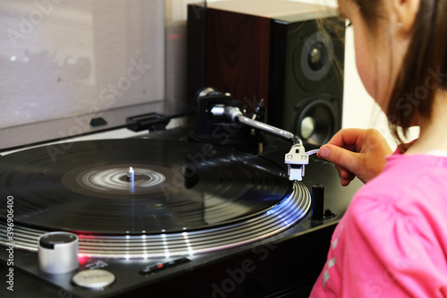 Young girl pleacing stylus on spinning record