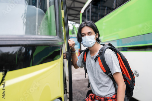 portrait of asian young man with mask riding a bus