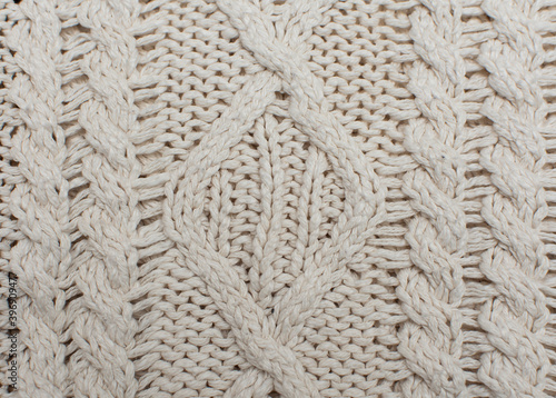 Knitted background, texture, pattern. Closeup of sample with knitting weave. Cable knitting.