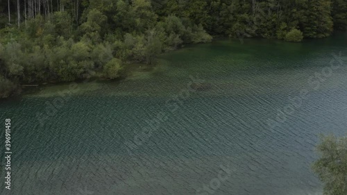 Freibach reservoir in the south Austrian Alps with calm water and small boats, Aerial pan right reveal shot photo