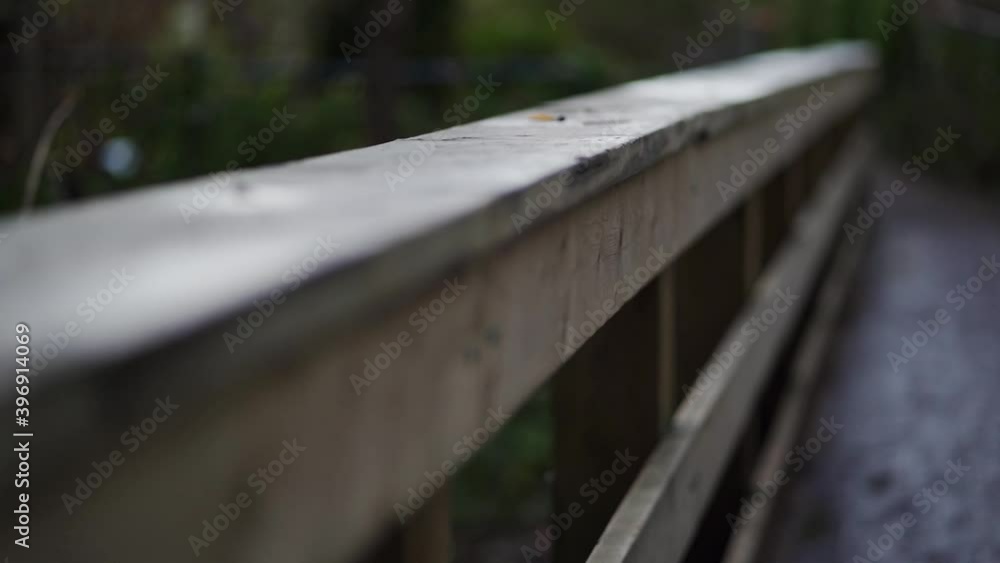 Slow moving close up shot of hand railing on a bridge going over a small creek. Slow moving close up shot of hand railing on a bridge going over a small creek.