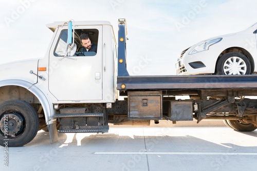 Obraz na plátně Operator towing a dead car on a tow truck