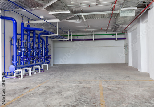 Parking garage interior, industrial building, hydrant with water hoses and fire extinguisher equipment , water pipe valve,pipe for water piping system control in industrial building