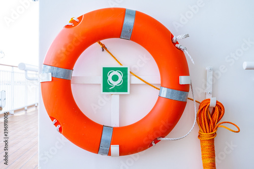 фотографія Orange lifebuoy or lifebelt emergency equipment device, hanging on ship exterior deck wall