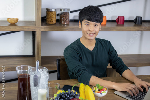 Young Asian man is sitting in a modern dining room