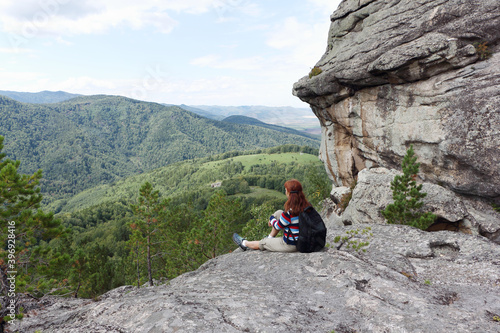 Happy woman sitting on the Ambarchiki rock , Belokurikha 2, Altai Mountains