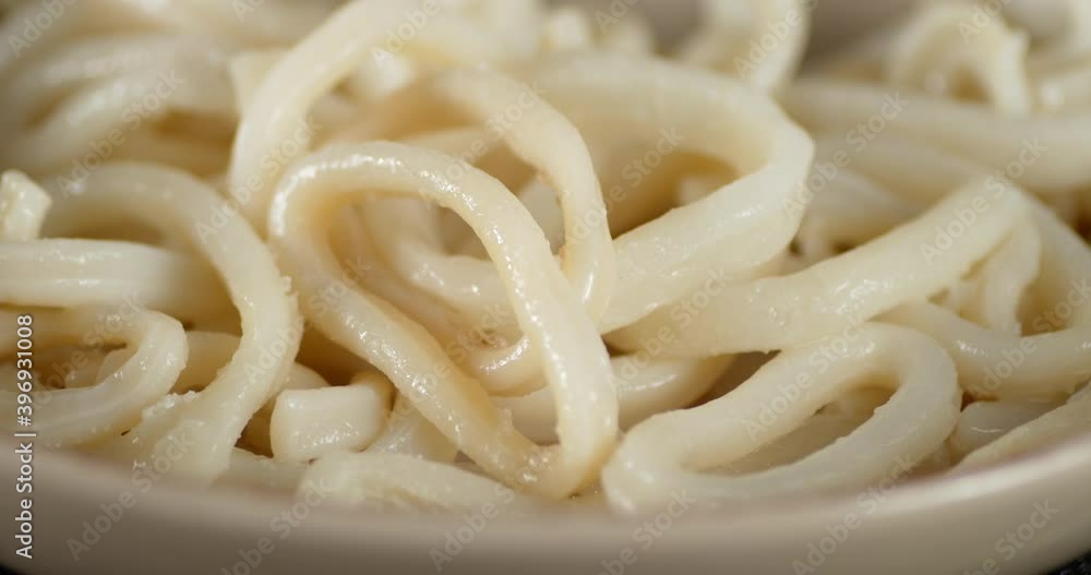 Bowl with fragrant delicious boiled squid rotates. 