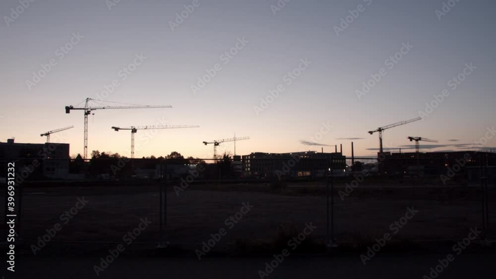 Silhouette of many cranes in the sky and modern buildings in a development area in Germany. Silhouette of many cranes in the sky and modern buildings in a development area in Germany.