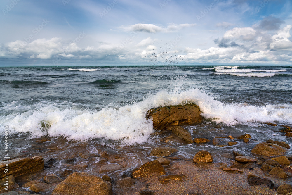 Empty rocky beach and stormy sea in cloudy weather Empty rocky beach and stormy sea in cloudy weather