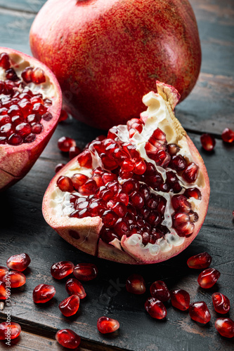 Ripe pomegranate with fresh juicy seeds, on old wooden table