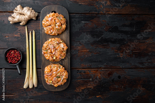 Quick asian raw fish patties with herbs, on old wooden table, flat lay with space for text