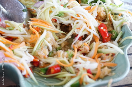 Papaya salad,food made from papaya with a variety of ingredients that are sour,sweet and spicy Is a very popular food in Thailand Anyone who eats deliciously. Somtam is yummy.Isolated white background