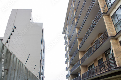 Tall Residential Skyscraper with Electric Fencing Against Cloudy Sky