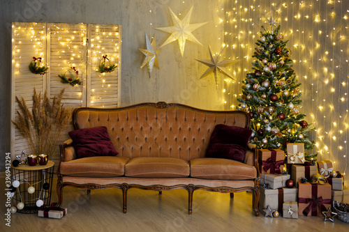 Christmas background - living room with Christmas tree  vintage sofa  festive garland led lights and wrapped gift boxes