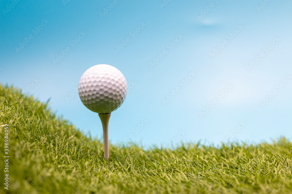 Golf ball is on tee on blue sky background Golf ball is on tee on blue sky background