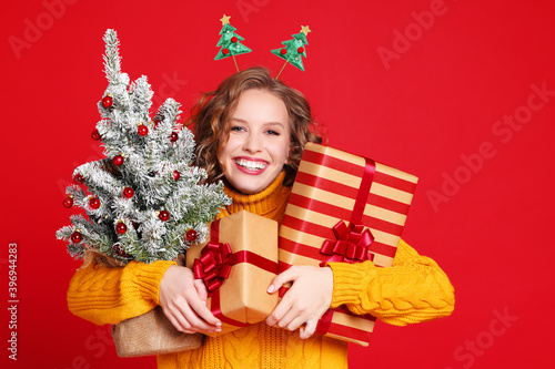 Delighted woman with gifts and Christmas tree