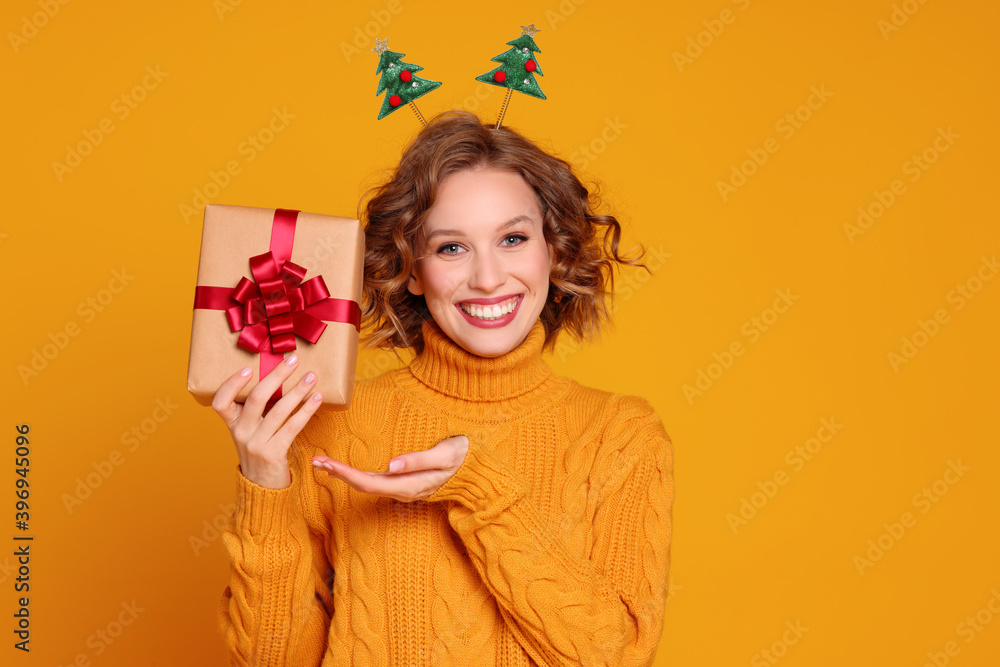Glad young female with Christmas gift. Glad young female with Christmas gift.