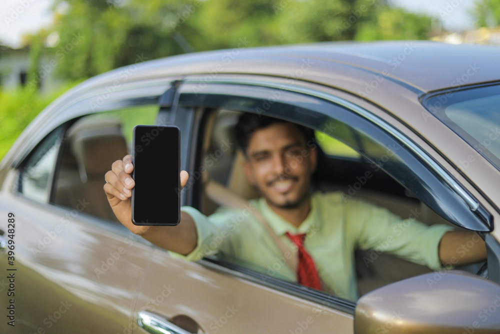 Young indian business man or employee sitting in car and showing mobile screen Young indian business man or employee sitting in car and showing mobile screen
