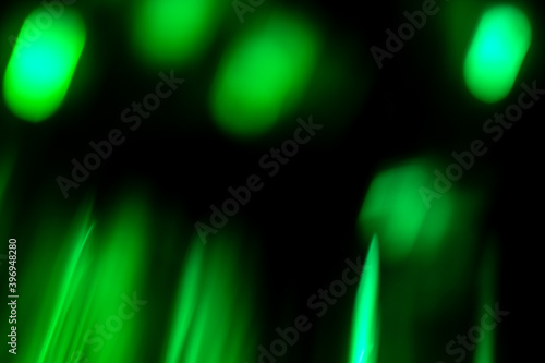 Defocused circles abstract green background of speed camera movement over glowing lights.