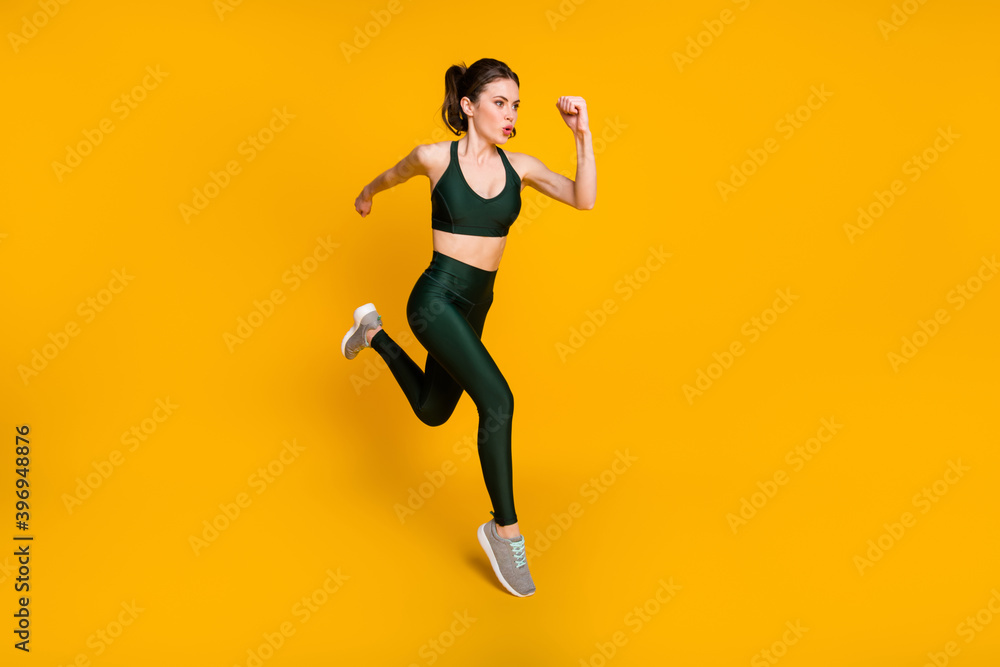 Full length photo of sportive lady running jogging cardio wear sports suit shoes isolated yellow color background