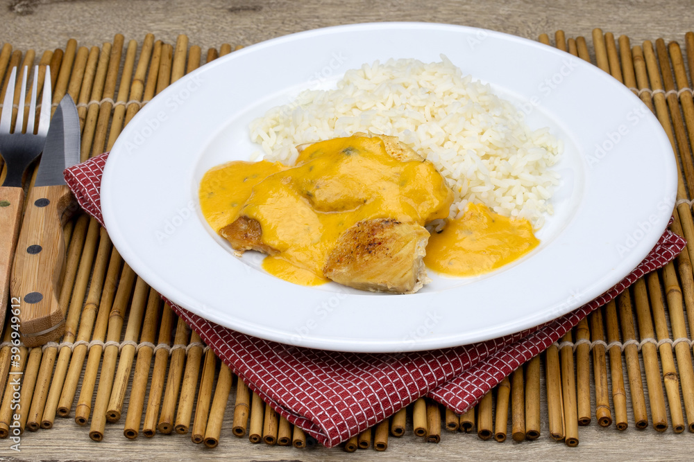 escalope de poulet , sauce au curry et riz dans une assiette escalope de poulet , sauce au curry et riz dans une assiette