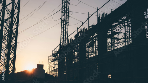 Silhouette Engineer and construction team working at site over blurred  industry background with Light fair Film Grain effect.Create from multiple reference images together